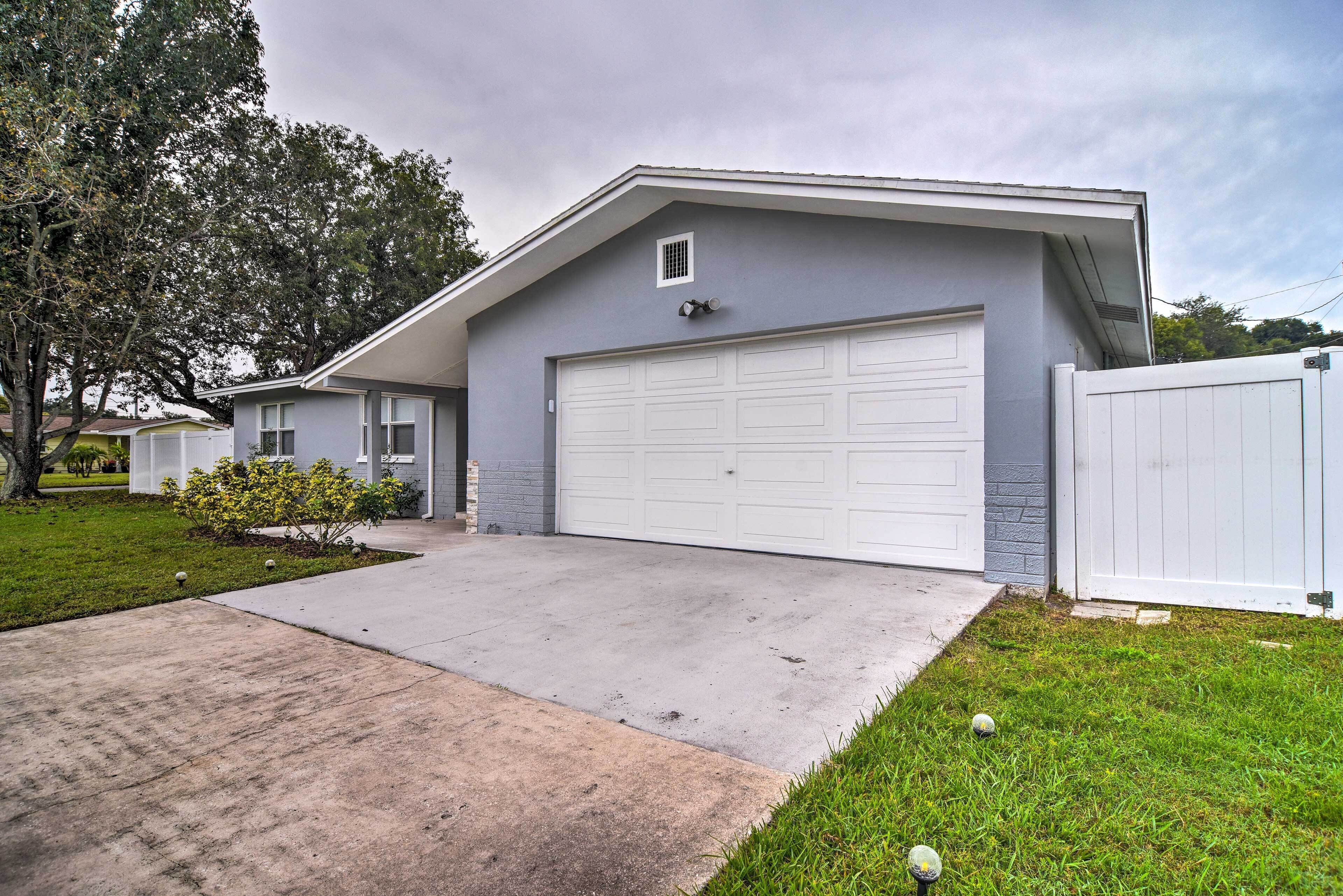 A single-story house with a garage, a front lawn, and a tree.