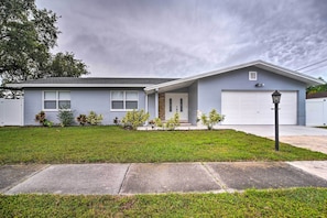 A single-story house with a garage, a front lawn, and a sidewalk.