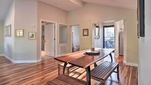 A spacious room with a wooden table and bench, a white door, and a view of the outside. - Vibrant Dunedin Getaway w/ Furnished Patio! (Dunedin)