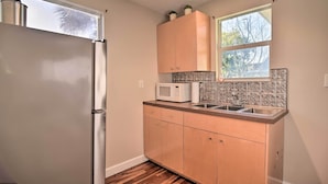 A compact kitchen with a refrigerator, microwave, and sink. - Vibrant Dunedin Getaway w/ Furnished Patio! (Dunedin)