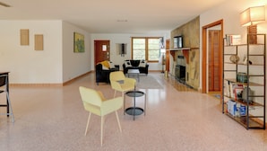 A spacious living area with a fireplace, a bookshelf, and a seating area with two couches and chairs. - Vacation Home Rental in Gainesville, Florida! (Gainesville)