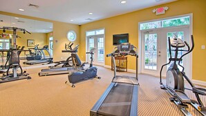 A gym with treadmills, elliptical machines, and a stationary bike.