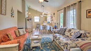 Ein geräumiges Wohnzimmer mit Deckenventilator, zwei Sofas, einem Couchtisch und einem Essbereich mit Tisch und Stühlen.