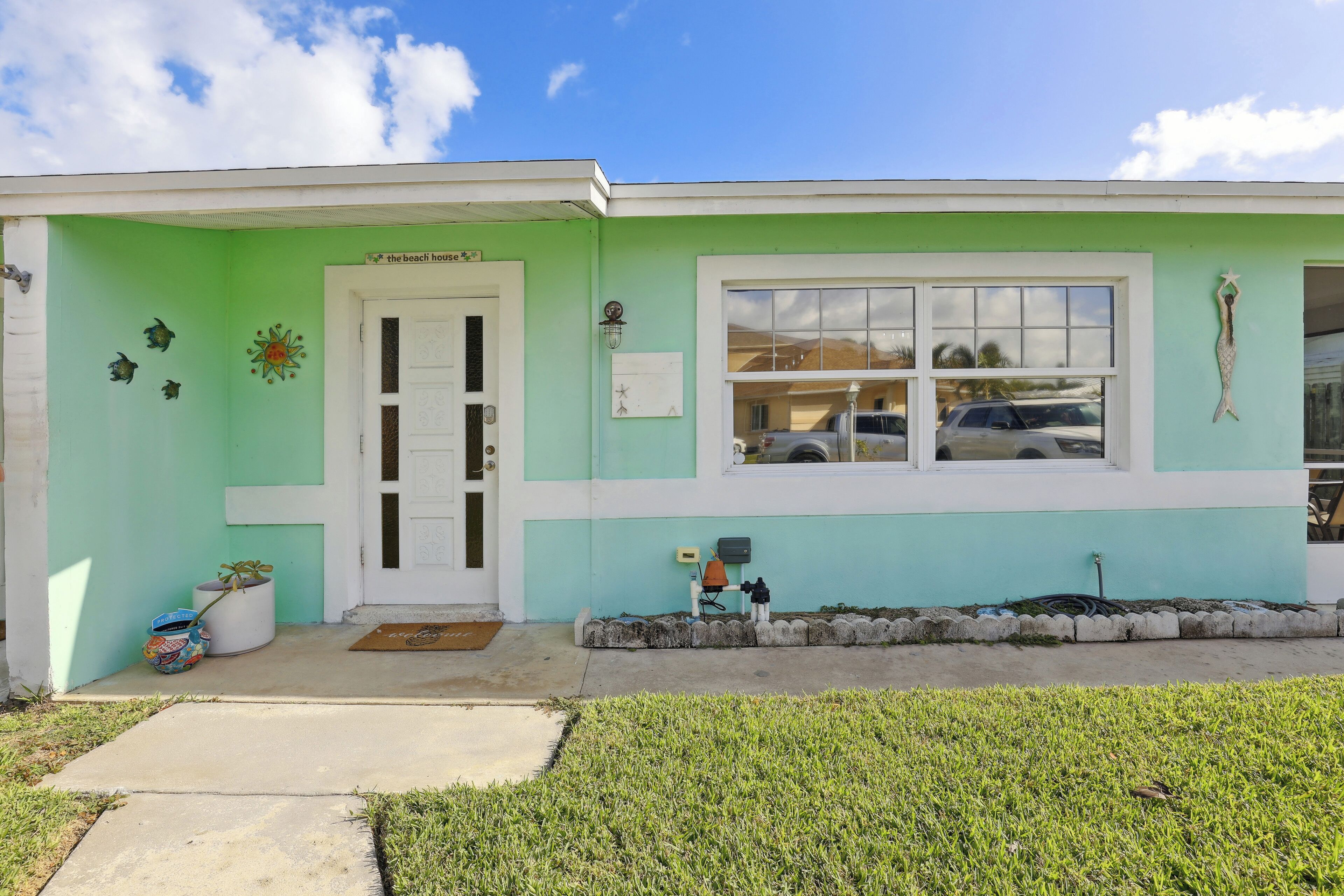A building with a green exterior, a white door, and a window.