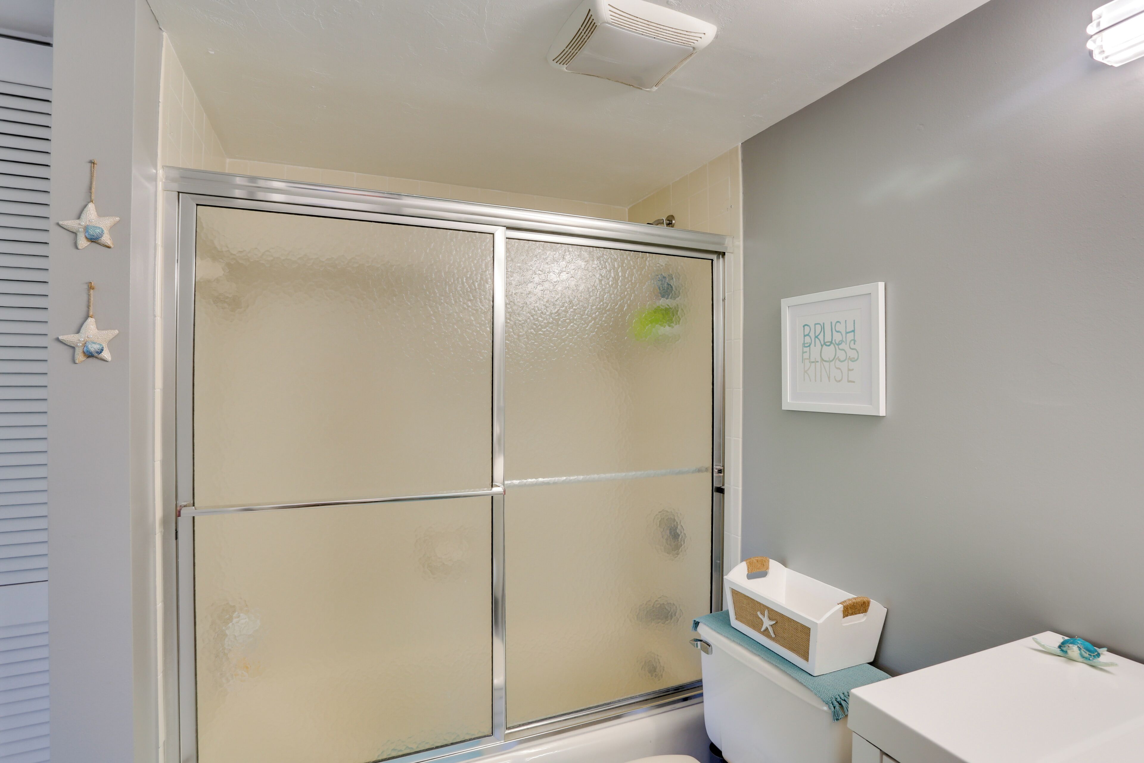 Un baño con cabina de ducha de vidrio, inodoro y lavabo.