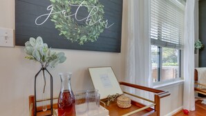 A room with a wooden bench, a wall-mounted sign reading "gather," a framed picture, and a tray with a vase and glasses. - Bluffton Vacation Rental w/ Private Hot Tub (Bluffton)