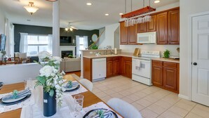 A modern kitchen with wooden cabinets, a white microwave, and a stainless steel refrigerator. - Bluffton Vacation Rental w/ Private Hot Tub (Bluffton)