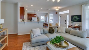 A spacious living room with a grey sectional sofa, a coffee table with a plant, and a dining area in the background. - Bluffton Vacation Rental w/ Private Hot Tub (Bluffton)