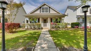 A two-story house with a front porch, a central entrance, and a pathway leading to the door. - Bluffton Vacation Rental w/ Private Hot Tub (Bluffton)