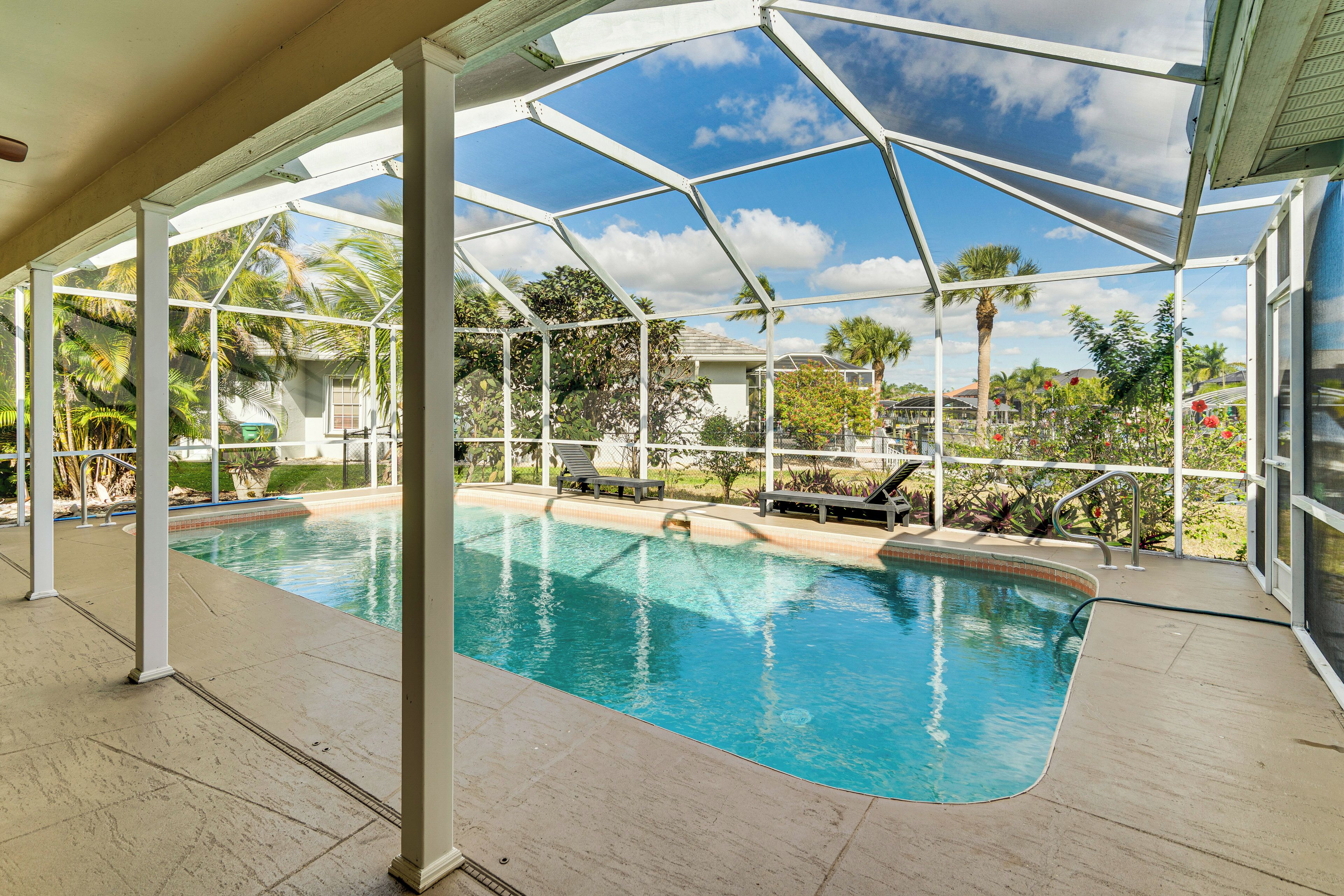 Una piscina techada con vistas a palmeras y casas.