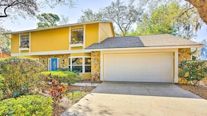 A two-story house with a garage, surrounded by well-maintained landscaping and trees. - Brandon Vacation Rental Home w/ Spacious Yard (Brandon)