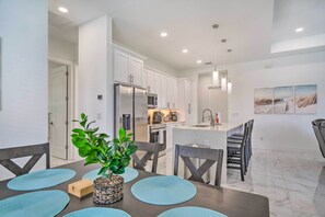 A modern kitchen with white cabinets, stainless steel appliances, and a central island. - Cape Coral Home w/ Screened-in Lanai + Pool! (Cape Coral)