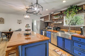A modern kitchen with blue cabinets, a wooden island, and a brick backsplash. - Charming Retreat on 20 Acres w/ Private Lake! (Walterboro)