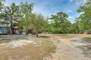 A rural property with a dirt yard, several trees, and a small building. - Charming Retreat on 20 Acres w/ Private Lake! (Walterboro)