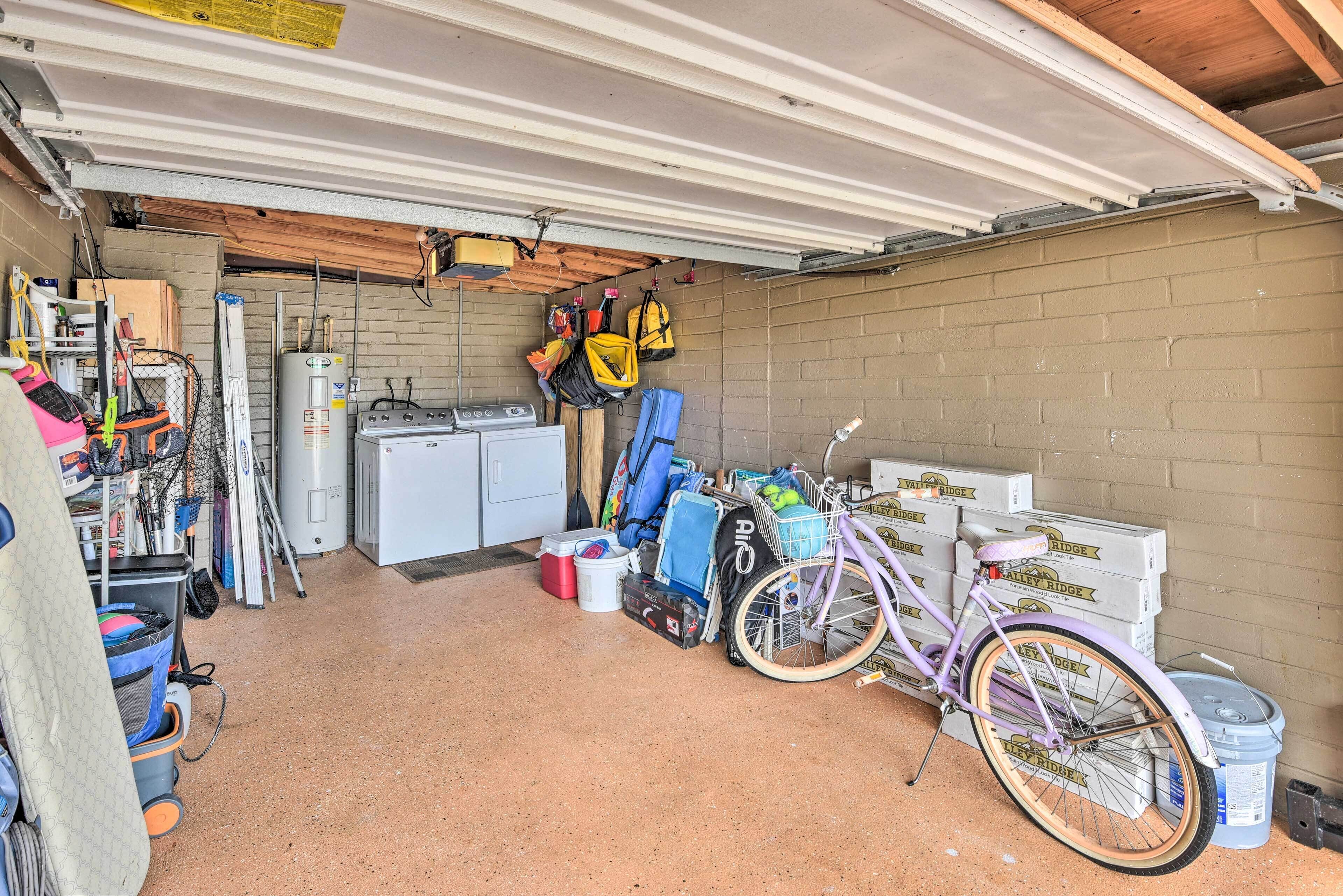 A garage with a bicycle, storage boxes, and various tools.