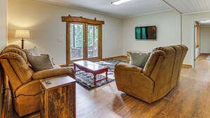 A living room with two leather sofas, a wooden coffee table, and a patterned rug. - Lake Hartwell Cabin, Perfect for Clemson Game Day (Fair Play)