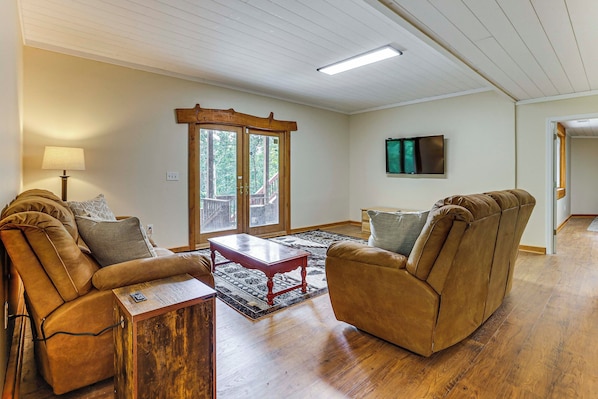 A living room with two leather sofas, a wooden coffee table, and a patterned rug. - Lake Hartwell Cabin, Perfect for Clemson Game Day (Fair Play)