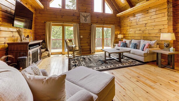 A log cabin with a wooden interior, a fireplace, a sofa, a coffee table, and a television. - Lake Hartwell Cabin, Perfect for Clemson Game Day (Fair Play)