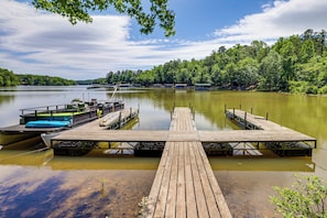 A wooden dock extending into a calm lake, surrounded by lush greenery. - Lake Hartwell Cabin, Perfect for Clemson Game Day (Fair Play)
