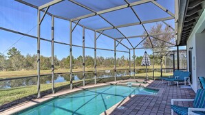 Une piscine extérieure couverte, avec une eau d ’un bleu limpide, entourée d’une structure métallique et dotée d’un espace ombragé.