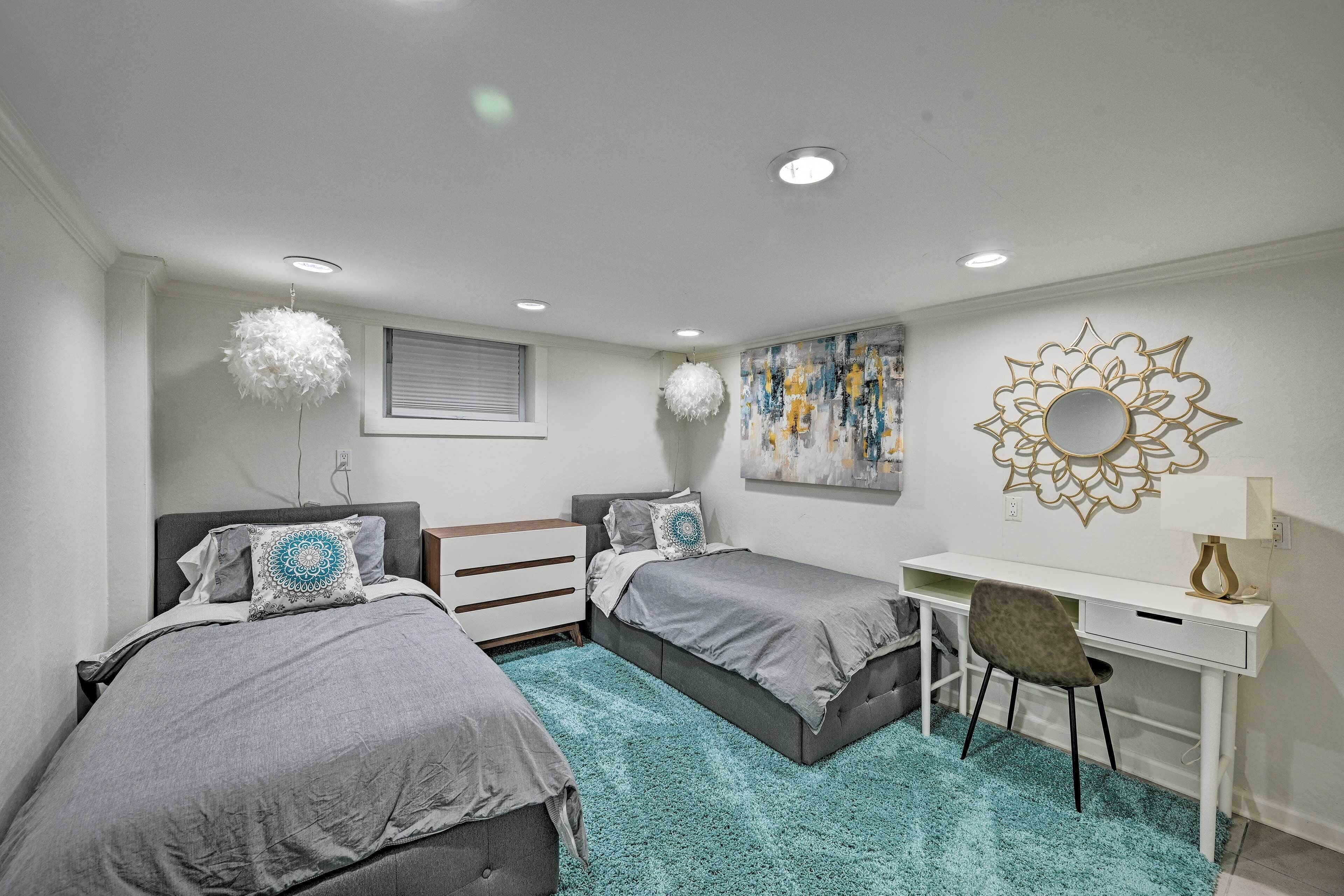 Un dormitorio con dos camas, un escritorio y una silla.