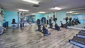 A gym with exercise equipment, a mirrored wall, and a wooden floor. - Pool, Spa & Dining: Beach Condo in Hilton Head! (Hilton Head Island)