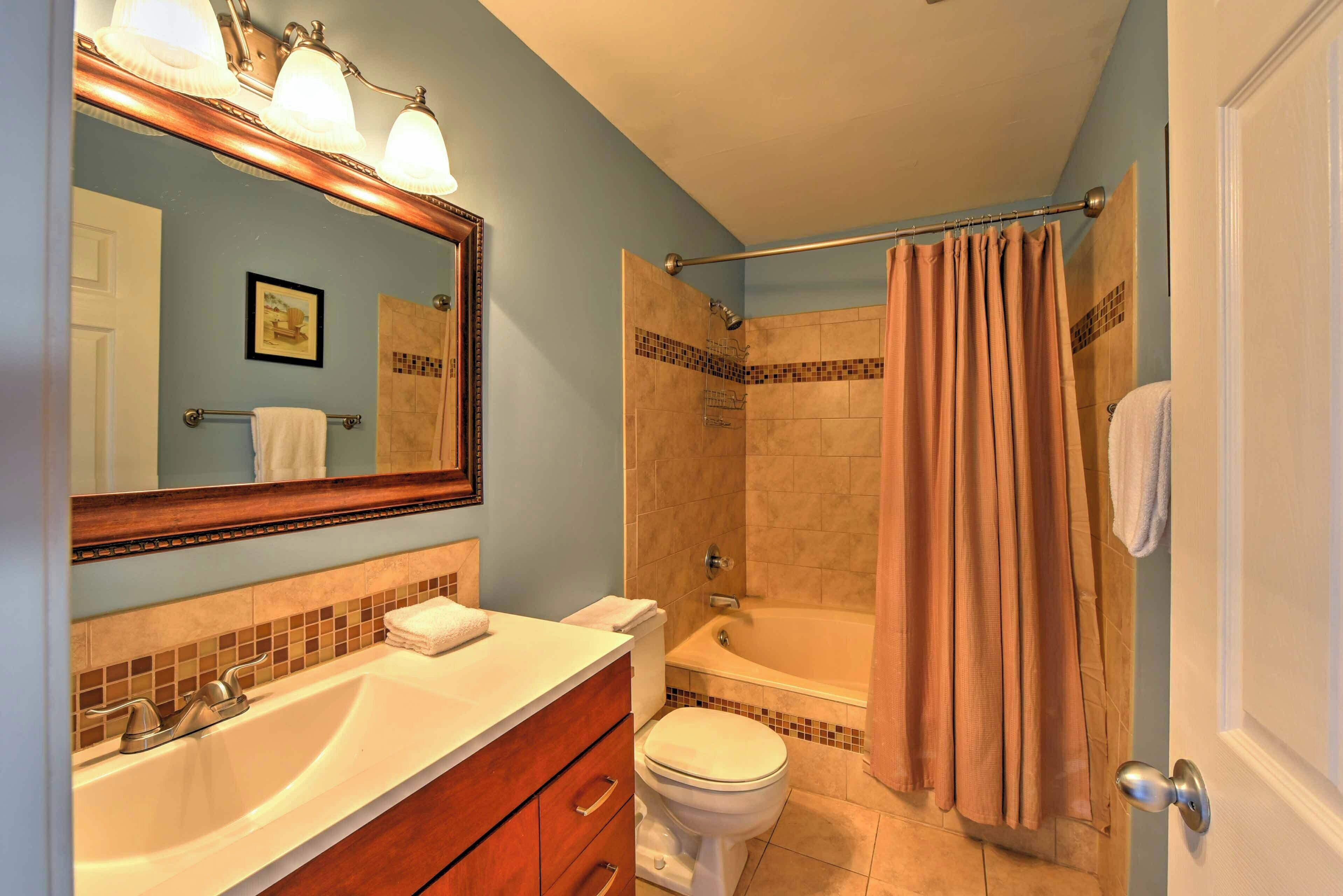 A bathroom with a sink, toilet, and bathtub.
