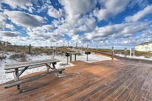 A wooden deck with picnic tables and signs, leading to a sandy beach area. - Cozy Destin Studio w/ Shared Pools + Beach Access! (Destin)