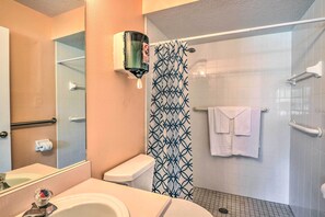 Un bagno con il water, lavandino e zona doccia.