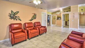 A spacious room with a ceiling fan, a wall-mounted clock, and a door leading to another room. - Cozy Coastal Retreat w/ Grill < 5 Mi to Beach (Port Orange)