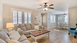 A spacious living room with a large sofa, a coffee table, and a dining area in the background. - Columbia Vacation Rental < 2 Mi to University (Columbia)