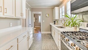 A kitchen with white cabinets, a stainless steel stove, and a potted plant. - Columbia Vacation Rental < 2 Mi to University (Columbia)
