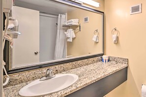 A bathroom with a granite countertop, a white sink, a large mirror, and a towel rack. - Cozy Studio Condo w/ Resort Amenities Access! (Myrtle Beach)