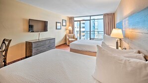 Habitación de hotel con dos camas, televisor, cómoda y balcón con vistas.