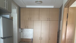 Eine Küche mit Holzausstattung, einem Marmorboden und einem eingebauten Kühlschrank.