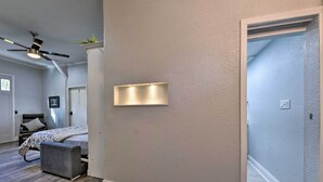 A bedroom with a bed, a bench, a ceiling fan, and a wall-mounted light fixture. - Cozy Jacksonville Studio - 10 Miles to Downtown! (Jacksonville)