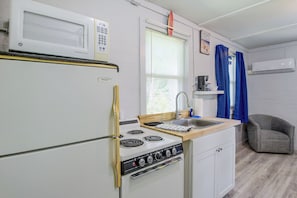 Une cuisine compacte équipée d’un four à micro-ondes, d’une cuisinière et d’un évier.