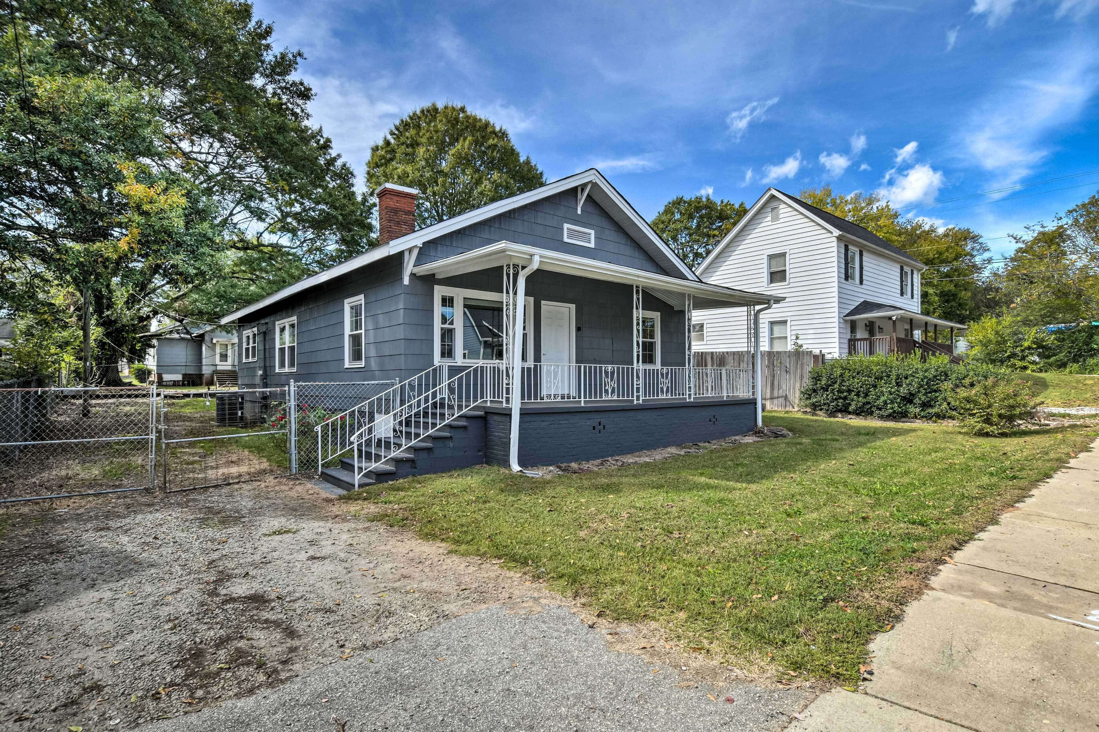 A two-story house with a front porch, a covered staircase, and a fenced yard.