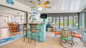 A spacious kitchen with a central island, bar stools, and a dining area with chairs. - Canal-front Outdoor Oasis: Home in Crystal Water (Crystal River)
