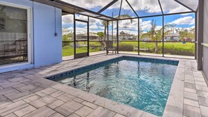 A covered swimming pool with a view of a residential area. - Englewood Escape w/ Screened-in Pool & Grill! (Englewood)