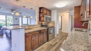 A modern kitchen with granite countertops, stainless steel appliances, and wooden cabinets. - Englewood Escape w/ Screened-in Pool & Grill! (Englewood)