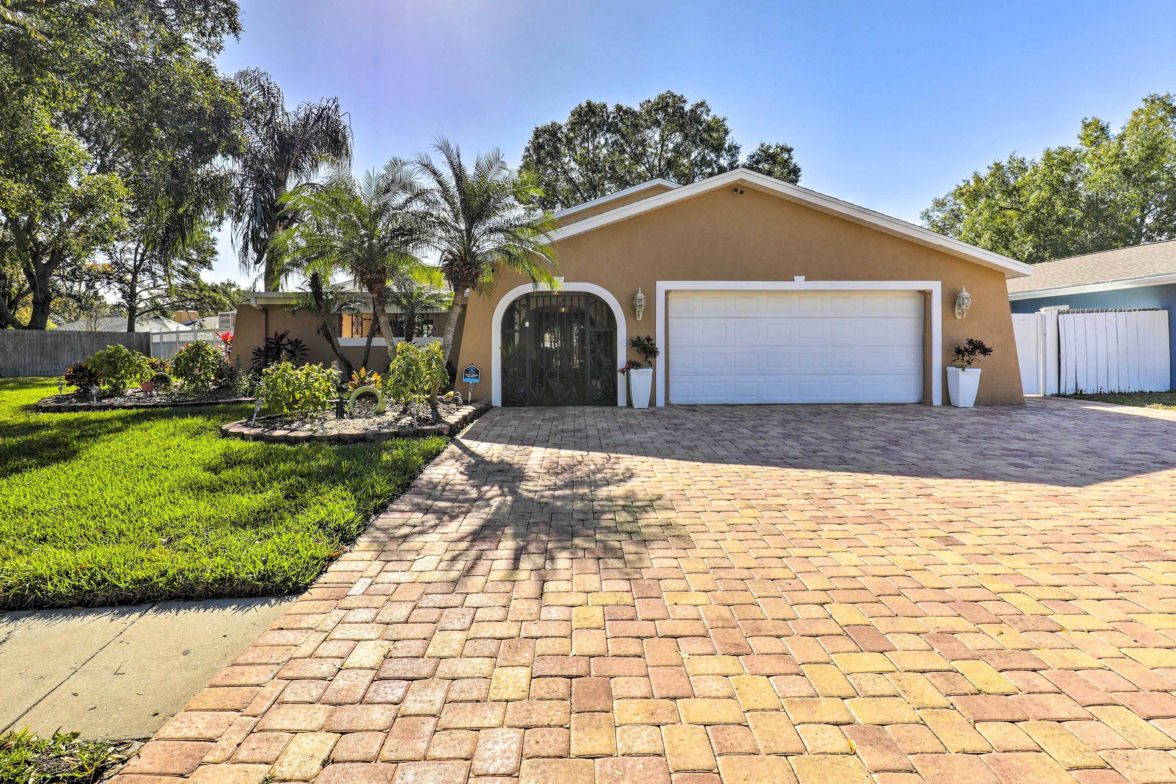 A single-story house with a garage, surrounded by a well-maintained lawn and a brick driveway.