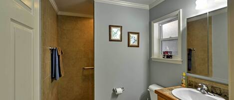 A bathroom with a toilet, sink, and shower.