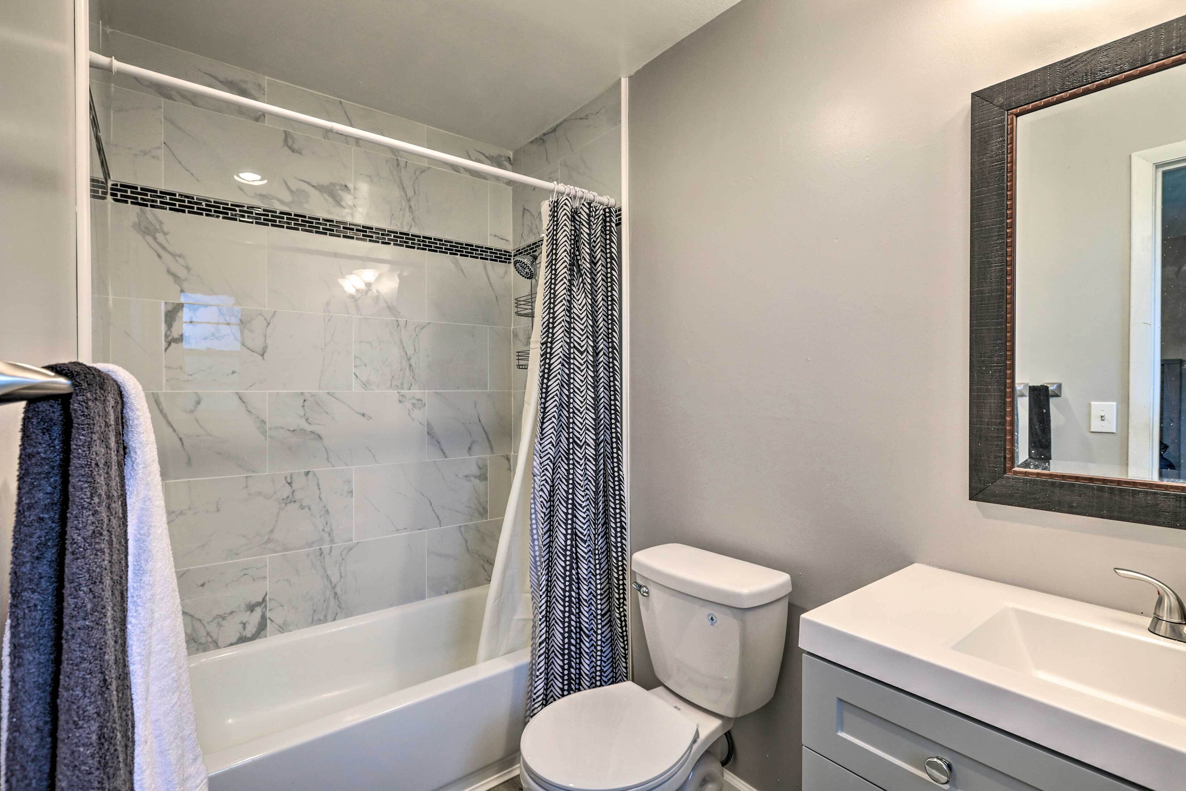 A bathroom with a bathtub, toilet, and sink.