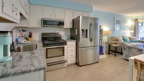 A modern kitchen with white cabinets, stainless steel appliances, and a marble countertop. - Steps to Beach, Coligny Plaza: Hilton Head Condo! (Hilton Head Island)