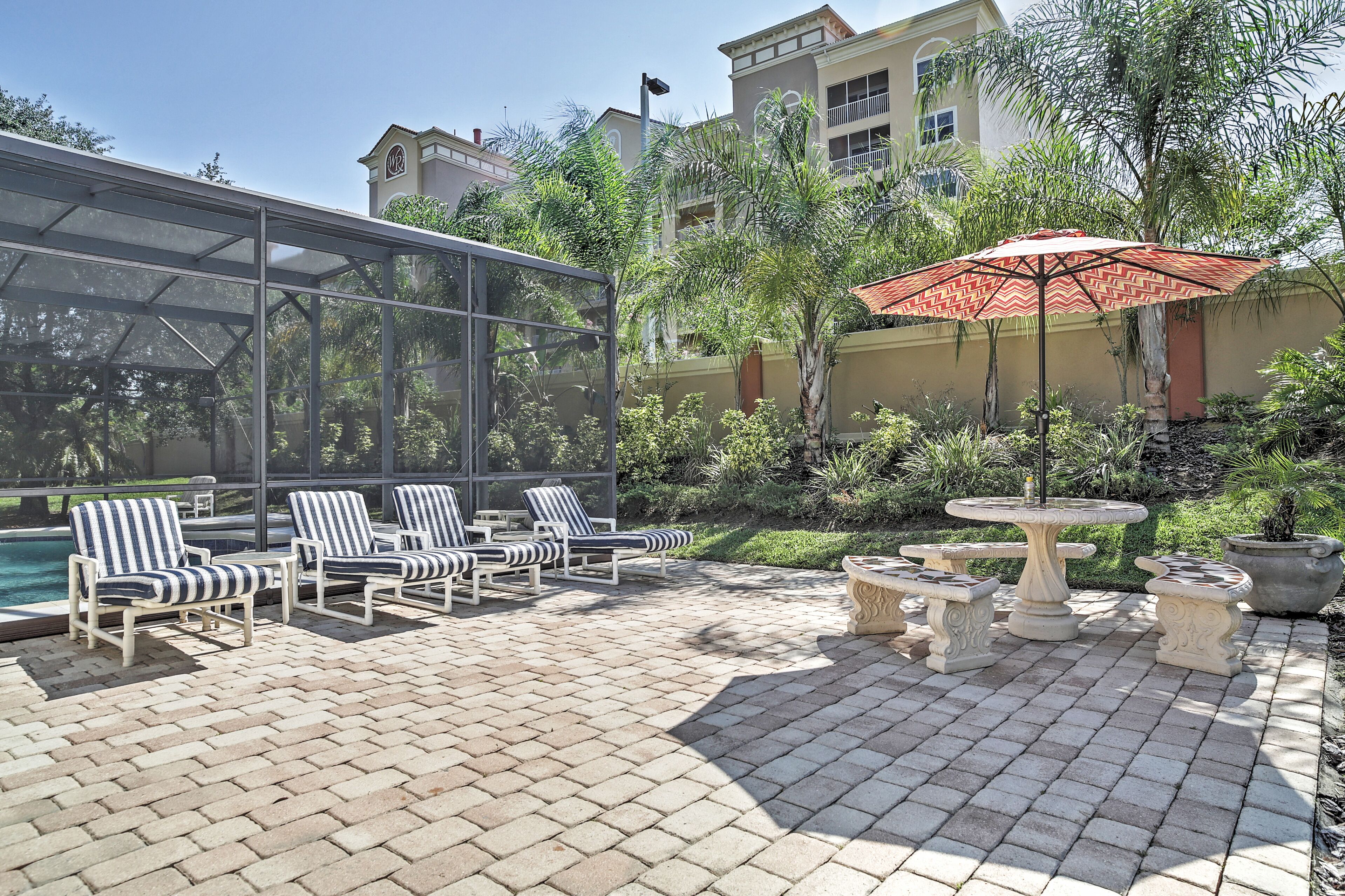 A patio area with lounge chairs, a table, and a decorative fountain.