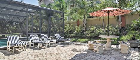 A patio area with lounge chairs, a table, and a decorative fountain.