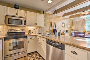 A modern kitchen with stainless steel appliances, white cabinetry, and a granite countertop. - Keowee Keys Home w/ Mountains View & Lake Access! (Salem)