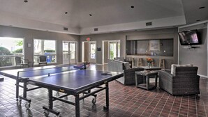 A spacious indoor area with a ping pong table, seating, and a television. - Walk to Beach: Resort-style Hilton Head Condo! (Hilton Head Island)