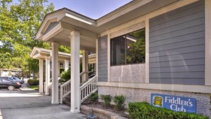 A building with a covered porch, a staircase, and a sign for 'Fiddler's Club'. - Walk to Beach: Resort-style Hilton Head Condo! (Hilton Head Island)